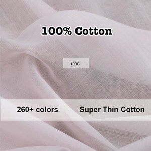 May include: Close-up of a soft, white, 100% cotton fabric. The fabric is very thin and has a subtle texture. The text "100% Cotton" and "Super Thin Cotton" is printed on the fabric. The text "100S" is printed on a white rectangle.
