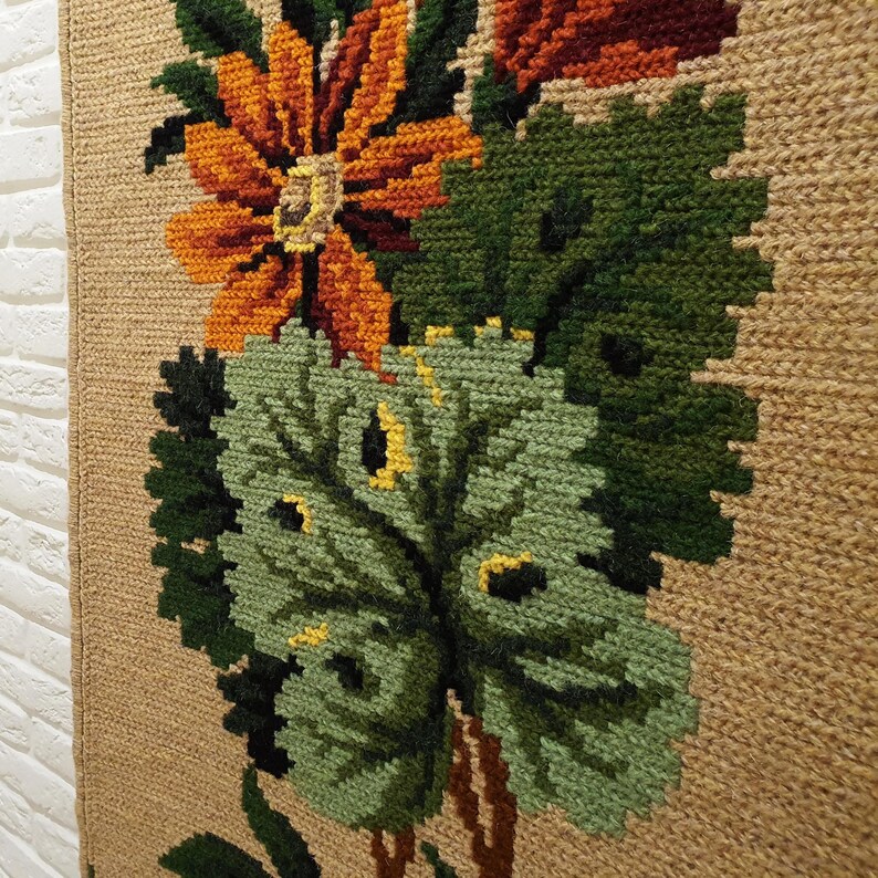 Wool tapestry style wall panel with green leaves and flowers, structured embroidery texture