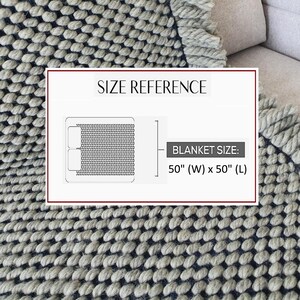 May include: A gray and navy blue woven blanket with a textured pattern and fringe detail. The blanket measures 50 inches wide by 50 inches long.