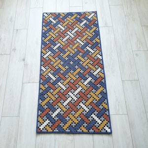 Full view of a handmade wool accent color rug on the floor.