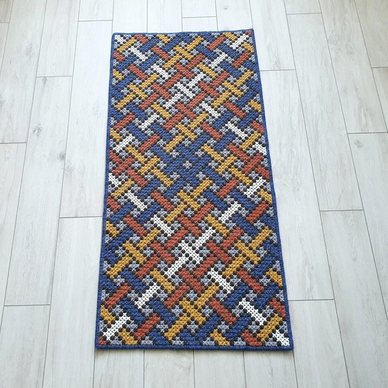 Full view of a handmade wool accent color rug on the floor.