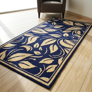 A handmade wool rug with embroidered yellow leaves on a dark blue background lies on the light wooden floor in the room.