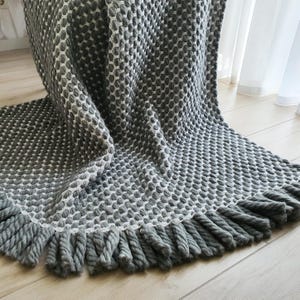 Chunky crochet blanket made of thick wool yarn with visible structure and natural imperfections