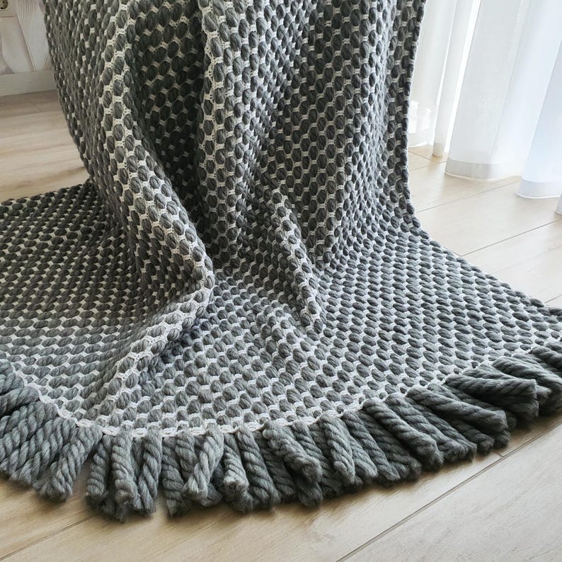 Chunky crochet blanket made of thick wool yarn with visible structure and natural imperfections