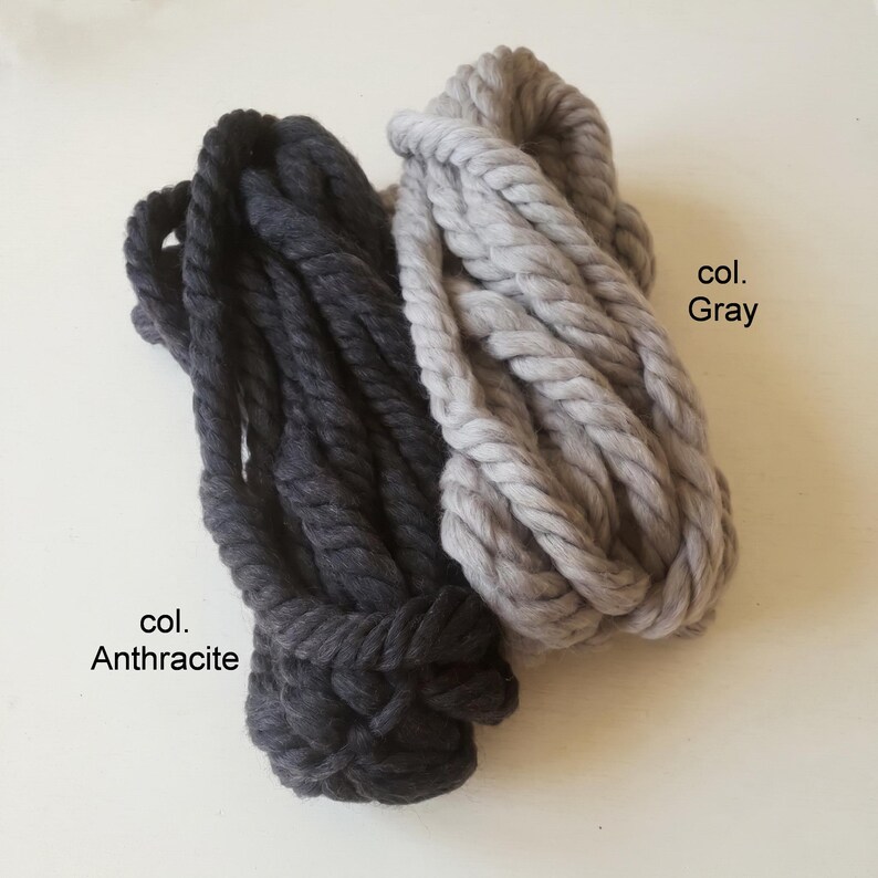 Two skeins of thick wool yarn in different colors: gray and anthracite.