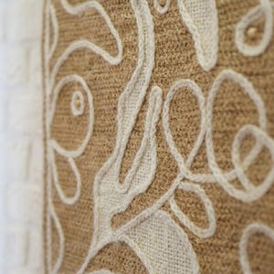 Wool wall art panel featuring organic shapes and visible stitched texture on a light base
