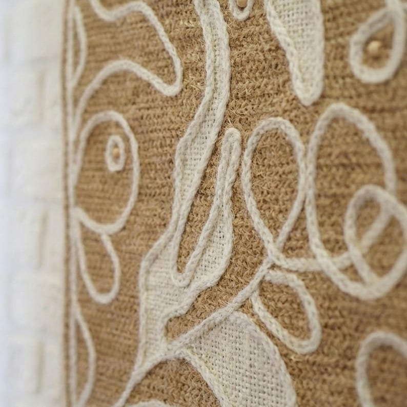 Wool wall art panel featuring organic shapes and visible stitched texture on a light base
