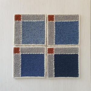 May include: Four square crochet coasters. Each coaster features a blue center, gray border, and a rust-colored square in the corner. The coasters are bordered with a cream-colored yarn.