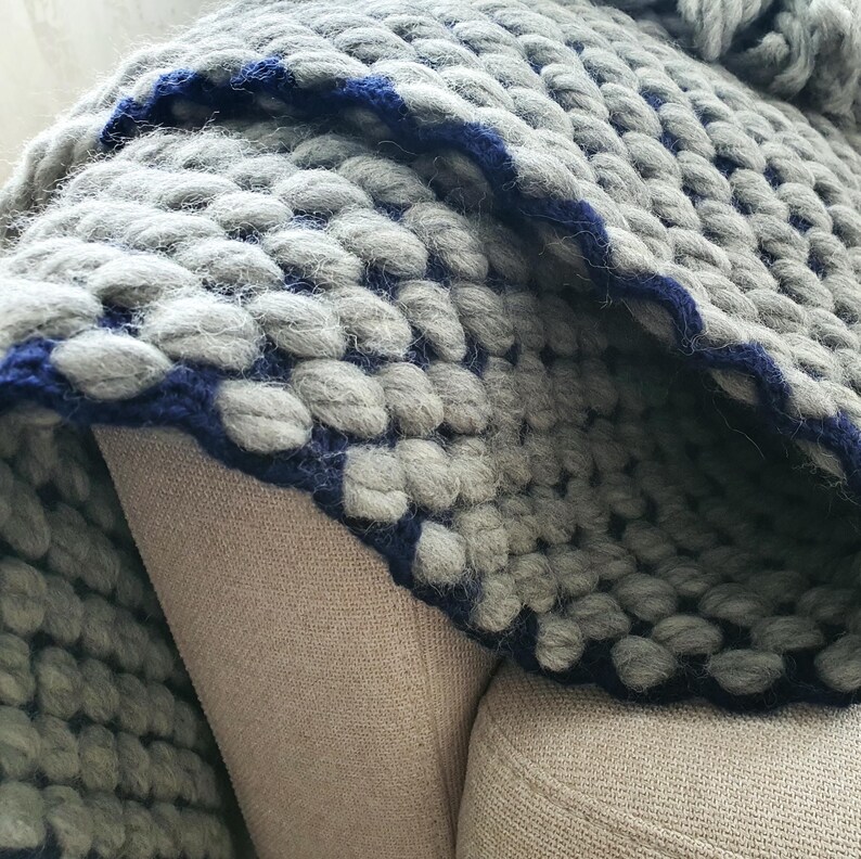 Edge detail of chunky knit blanket showing thick yarn loops and finishing.