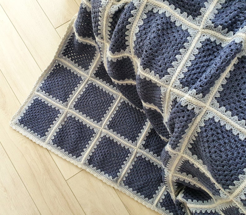 May include: A crocheted throw blanket with a square pattern in shades of blue and white.