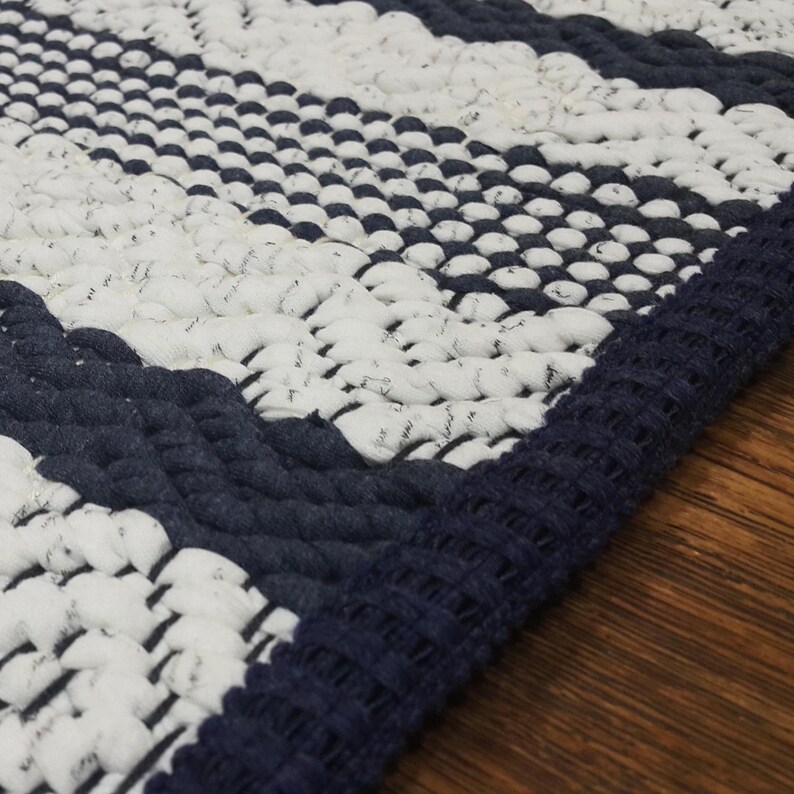 Close-up of cotton rug texture with visible loops and woven stripe pattern.