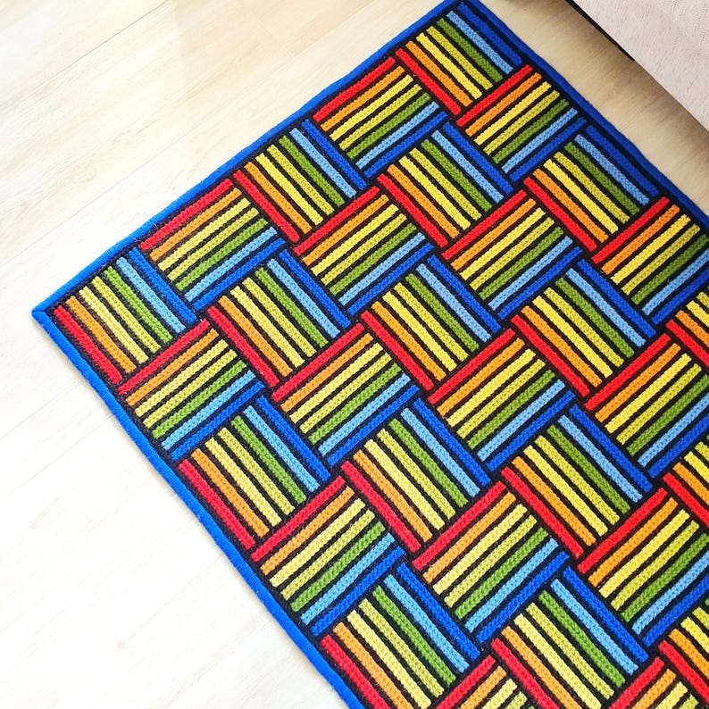 Side view of the rug showing the blue border and raised stitch texture.