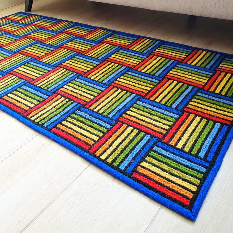 Hand-stitched textile art floor mat with saturated yellow, orange, and blue hues.