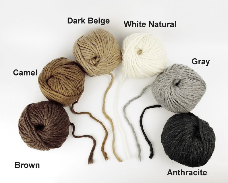 May include: Balls of yarn in various shades of brown, beige, grey, and black. The colours are labelled "Camel", "Dark Beige", "White Natural", "Grey", "Brown", and "Anthracite".