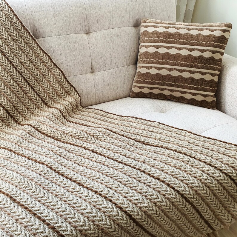 Detail of a crochet blanket with visible handmade stitches and natural irregularities.