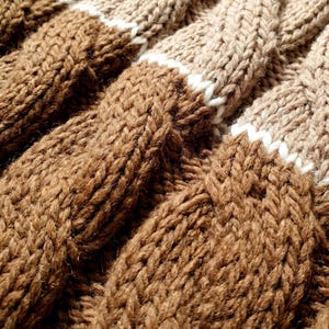 close-up the texture of a knitted merino wool blanket with a cable pattern.