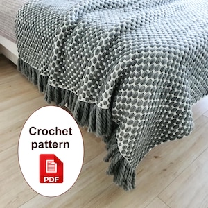 Może przedstawiać: Szaro-biały koc zrobiony na szydełku z wzorem i frędzlami. Koc jest narzucony na łóżko. Obraz zawiera tekst "Crochet pattern" i ikonę PDF.
