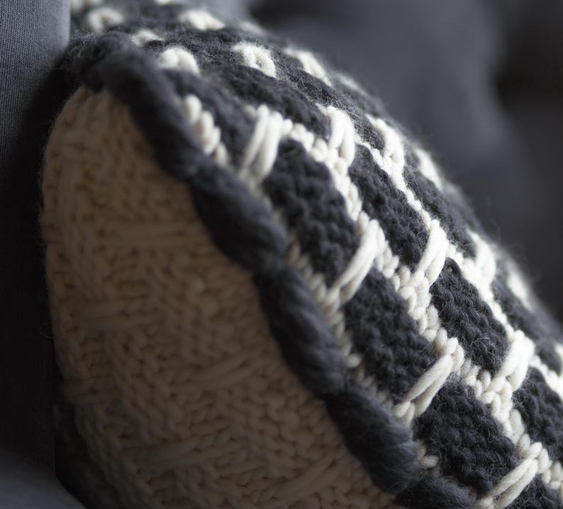 Close up of chunky knit wool texture. Natural breathable fiber cushion cover in white and black yarn for cozy home