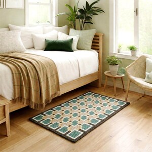 Handmade wool rug in Beige, Brown, Green and Teal tones placed beside a bed in the bedroom, geometric pattern visible, soft natural light.