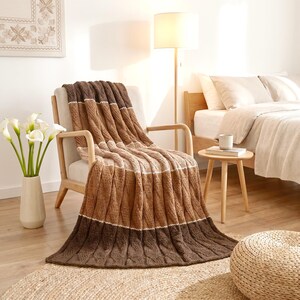 Handmade Knitted Striped Merino Wool Throw Blanket Brown Beige on an armchair in a contemporary bedroom