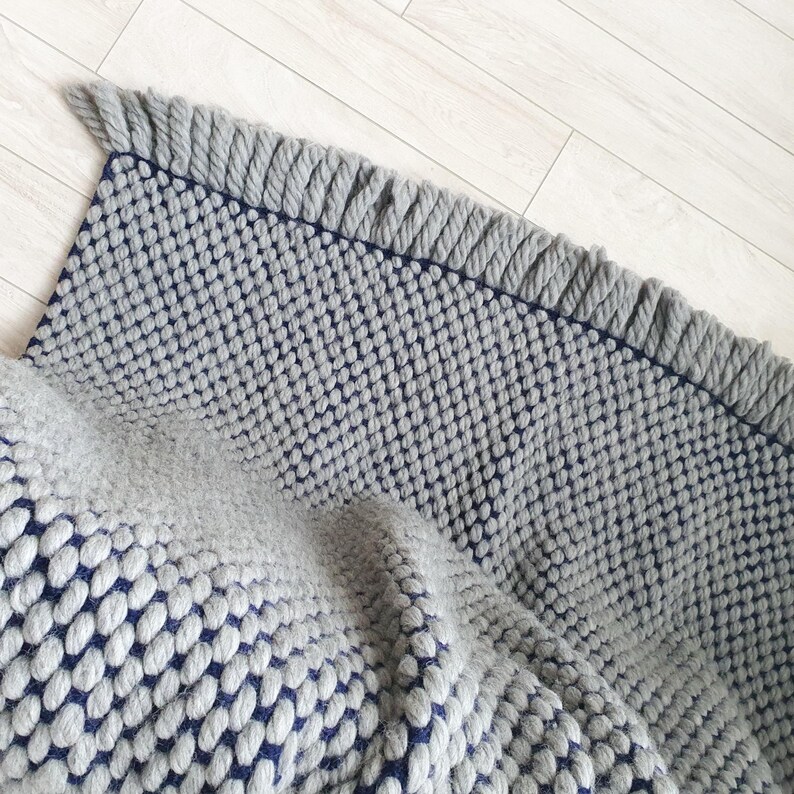 Edge detail of chunky knit blanket showing thick yarn loops and finishing.