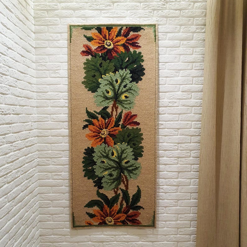 Wool wall hanging with floral embroidery and green leaves, handmade textile wall art with visible texture