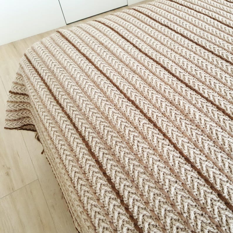 Textured crochet wool throw in beige color used as a sofa blanket in modern interior