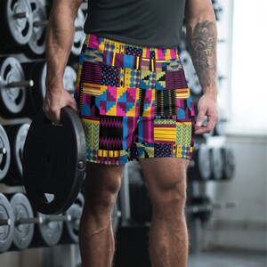 May include: A pair of athletic shorts with a colorful geometric pattern in shades of yellow, blue, pink, and black.