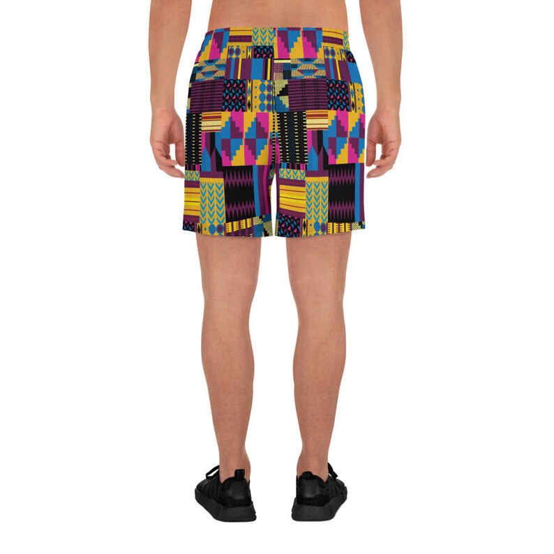 May include: A pair of athletic shorts with a colorful geometric pattern in shades of yellow, blue, pink, and black.