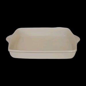 May include: A rectangular, off-white baking dish with rounded corners and two small handles. The dish has a smooth, glossy finish and is set against a black background. This versatile dish is suitable for baking and serving.
