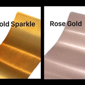 May include: Two rectangular metal swatches displayed side by side. The left swatch is a metallic gold with a subtle sparkle finish, labeled Gold Sparkle. The right swatch is a metallic rose gold with a fine, shimmering texture, labeled Rose Gold.