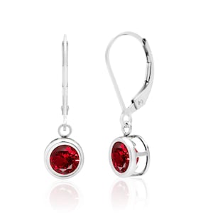 May include: A pair of silver dangle earrings with red oval-shaped gemstones. The earrings have a lever back closure.