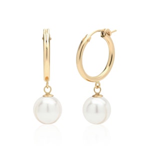 May include: Gold hoop earrings with a single white pearl dangling from each hoop.