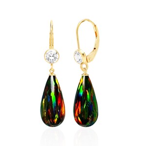May include: A pair of gold-colored drop earrings. Each earring features a clear, round gemstone at the top and a teardrop-shaped, black opal pendant with vibrant green, red, and yellow hues. The earrings have a lever-back closure.