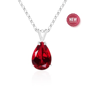 May include: A silver necklace with a pear-shaped red gemstone pendant.