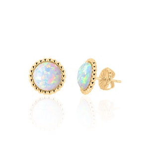 May include: A pair of gold earrings with a white opal gemstone set in a beaded bezel. The earrings have a post and butterfly back.