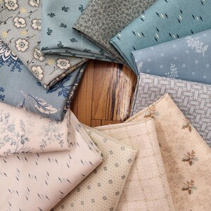 May include: A collection of folded fabric swatches arranged in a circular pattern, featuring various patterns including floral prints, geometric grids, small dots, and dashes in shades of light blue, sage green, cream, and beige.