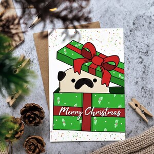 Cartolina di Natale: Carlino nella confezione regalo "Buon Natale" biglietto di auguri per le festività natalizie