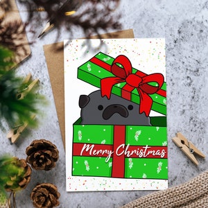 Tarjeta de Navidad: Pug negro en caja de regalo Tarjeta de felicitación "Feliz Navidad" para la temporada navideña