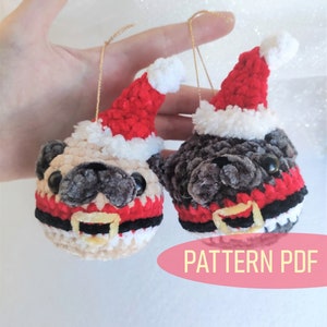 Pu&ograve; includere: Due ornamenti di pug in crochet che indossano cappelli di Babbo Natale e abiti rossi e bianchi. Gli ornamenti sono appesi a stringhe dorate. Il testo "PATTERN PDF" &egrave; visibile nell'immagine.