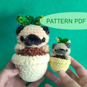 Puede incluir: Dos peluches de perro pug tejidos a crochet en macetas. El pug más grande está en una maceta de color melocotón con hojas verdes en la parte superior de su cabeza. El pug más pequeño está en una maceta amarilla con hojas verdes en la parte superior de su cabeza. El texto "PATTERN PDF" está en un óvalo verde en la esquina superior derecha de la imagen.