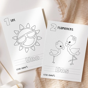 Könnte beinhalten: Zwei weiße Karten mit schwarzen Strichzeichnungen. Eine Karte zeigt eine Sonne mit Sonnenbrille und dem Wort "Uno" darunter. Die andere Karte zeigt zwei Flamingos mit dem Wort "Dos" darunter. Die Worte "con amor" stehen unten auf jeder Karte.