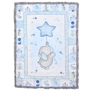 May include: A blue and gray baby blanket with a white background. The blanket features a gray elephant holding a blue star balloon. The blanket is surrounded by a blue and white border with stars and moons.