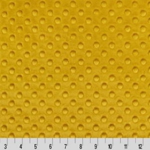 May include: A close-up of a yellow fabric with a textured pattern of small circles. The fabric has a soft, plush feel.