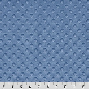 May include: A close-up of a blue fabric with a textured pattern of small, raised circles. The fabric has a soft, plush feel.