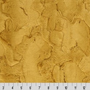 May include: A close-up of a soft, plush fabric in a warm, golden yellow color. The fabric has a fuzzy, textured surface that resembles fur.