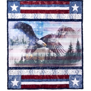 May include: A red, white, and blue American flag quilt with an eagle flying over a mountain range. The quilt is made of soft, plush fabric and features a patriotic design.