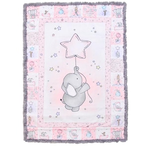 May include: A pink and gray baby blanket with a gray elephant holding a pink star balloon. The blanket has a white background with a pink and gray border. The blanket is decorated with stars and other small details.