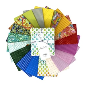 May include: A set of 18 fabric squares in various colors and patterns, including green, yellow, blue, red, and pink. The fabric squares are arranged in a fan shape and are tied together with a white ribbon. The fabric squares are labeled "Free Spirit".