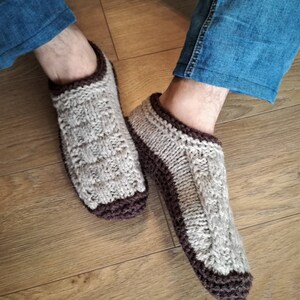 May include: A pair of knitted brown and beige slipper socks with a cable knit pattern.